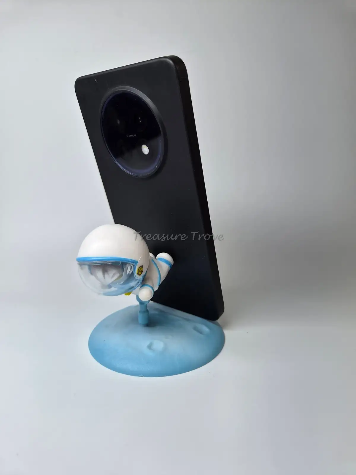 Flying Astronaut Mini Collectible on Blue Planet Base Phone
